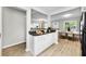 Bright kitchen featuring wood floors, white cabinets, and a dining area with plentiful natural light at 717 Pinewood Dr, Dunedin, FL 34698