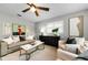 Inviting living room featuring a cozy couch, stylish decor, modern ceiling fan and plantation shutters at 717 Pinewood Dr, Dunedin, FL 34698