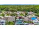 An aerial view showcases a charming neighborhood with lush trees and well-maintained homes, some with pools and solar panels at 9707 Kings Canyon Pl, Tampa, FL 33634
