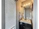 Powder room showcasing a vanity with black cabinetry, a white countertop, a bright mirror and white blinds at 9707 Kings Canyon Pl, Tampa, FL 33634