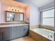 Bathroom vanity featuring a glass bowl sink, modern gray cabinets, and framed mirror with decorative lighting at 9707 Kings Canyon Pl, Tampa, FL 33634