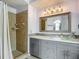 Bathroom featuring a vanity with a glass bowl sink, framed mirror, and a tiled walk-in shower with neutral-colored tile at 9707 Kings Canyon Pl, Tampa, FL 33634
