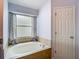 Bathroom with a soaking tub and window at 9707 Kings Canyon Pl, Tampa, FL 33634