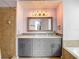 Bathroom vanity showcasing a glass bowl sink, gray cabinets, marble countertop, and tile backsplash and accent wall at 9707 Kings Canyon Pl, Tampa, FL 33634