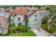 Two-story house featuring a red roof, a two-car garage, solar panels and tropical landscaping at 9707 Kings Canyon Pl, Tampa, FL 33634