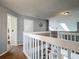 Second floor hallway showcasing a white railing, a neutral carpet and access to multiple rooms at 9707 Kings Canyon Pl, Tampa, FL 33634