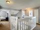 Bright hallway featuring white railing with carpeted steps leading to multiple bedroom entrances at 9707 Kings Canyon Pl, Tampa, FL 33634