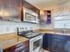 Well-appointed kitchen with stainless steel appliances, dark brown cabinets and light granite countertops at 9707 Kings Canyon Pl, Tampa, FL 33634