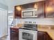 A well-lit kitchen showcasing stainless steel appliances and dark brown cabinetry at 9707 Kings Canyon Pl, Tampa, FL 33634
