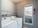 Bright laundry room area with washer, dryer and window for natural light at 9707 Kings Canyon Pl, Tampa, FL 33634
