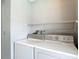 Functional laundry area equipped with washer and dryer and shelving for organized storage at 9707 Kings Canyon Pl, Tampa, FL 33634