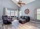 Bright living room has vaulted ceiling, wood floors, and large windows overlooking the backyard at 9707 Kings Canyon Pl, Tampa, FL 33634