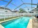 Beautiful screened pool area surrounded by a well-maintained fence and a bit of lawn at 9707 Kings Canyon Pl, Tampa, FL 33634