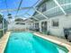 Refreshing screened-in pool with a seating area, ideal for relaxation and outdoor enjoyment at 9707 Kings Canyon Pl, Tampa, FL 33634
