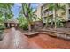 Community courtyard with brick patio, tropical landscaping, seating, and access to community amenities at 1000 W Horatio St # 129, Tampa, FL 33606