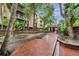 Scenic brick path leading to community amenities, lined with tropical trees and landscaping at 1000 W Horatio St # 129, Tampa, FL 33606