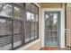 Exterior shot of a door with window panes and a nearby window with blinds at 1000 W Horatio St # 129, Tampa, FL 33606