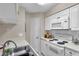 Efficient kitchen featuring white cabinets, white appliances, and a serving bar at 1000 W Horatio St # 129, Tampa, FL 33606