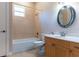 Cozy bathroom featuring a tub, shower, toilet, and vanity with a round mirror at 1137 Pristine Pl, Lutz, FL 33549