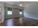 Large primary bedroom featuring hardwood floors, two windows, and a ceiling fan at 1137 Pristine Pl, Lutz, FL 33549