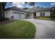 Single-story home with a spacious driveway and well-manicured lawn and flower beds at 1137 Pristine Pl, Lutz, FL 33549