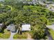 Aerial view of the home with a metal roof on a partially fenced lot in a neighborhood near a highway at 116 Hermes Rd, Venice, FL 34293