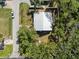 Aerial view of the home with a new metal roof and partially fenced in yard with mature trees on a quiet street at 116 Hermes Rd, Venice, FL 34293
