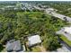 Aerial view of the home with a metal roof on a partially fenced lot in a neighborhood near a highway at 116 Hermes Rd, Venice, FL 34293