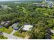 Aerial view of the home with a metal roof on a partially fenced lot in a neighborhood near a highway at 116 Hermes Rd, Venice, FL 34293