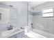 Bathroom featuring tile surround, updated fixtures, vanity and natural light from the window at 116 Hermes Rd, Venice, FL 34293