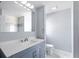 Bright bathroom featuring blue vanity, marble countertops, and a shower with stone and tile accents at 116 Hermes Rd, Venice, FL 34293