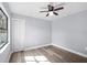 Bedroom featuring hardwood floors, a ceiling fan, and a closet illuminated by natural light from the window at 116 Hermes Rd, Venice, FL 34293
