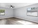 Bright bedroom with hardwood floors, ceiling fan, and natural light from the windows at 116 Hermes Rd, Venice, FL 34293