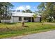 Charming single-story home with a metal roof, fresh white siding, and a well-maintained front lawn at 116 Hermes Rd, Venice, FL 34293