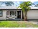 Welcoming front porch with a decorative railing and a modern entry door, enhanced by a lush palm tree at 116 Hermes Rd, Venice, FL 34293