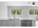 The kitchen area offers white cabinets and stone countertops with a view of tropical foliage at 116 Hermes Rd, Venice, FL 34293