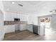 Bright open kitchen featuring stainless appliances, white cabinets, and large island with sink at 116 Hermes Rd, Venice, FL 34293