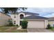 Two-story home boasts a lush lawn, landscaped garden, and a two-car garage at 1209 Alhambra Crest Dr, Ruskin, FL 33570