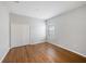 Bright bedroom featuring hardwood floors, neutral walls, and a closet with bi-fold doors at 12117 Streambed Dr, Riverview, FL 33579
