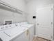 Functional laundry room with modern washer and dryer, shelving, and a neutral color palette at 12117 Streambed Dr, Riverview, FL 33579