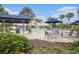 Community pool area featuring an outdoor lounge, tables and chairs, and lush tropical landscaping at 12117 Streambed Dr, Riverview, FL 33579