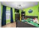 Vibrant bedroom featuring bright green walls, a bed, a window, and furnishings at 17071 Oval Rum Dr, Wimauma, FL 33598