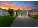Charming single-Gathering home featuring a well-maintained lawn, driveway, and one-car garage, dusk at 17071 Oval Rum Dr, Wimauma, FL 33598