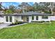 Charming single-story home with manicured lawn, crisp white paint, and contemporary black trim at 203 Driftwood W Dr, Palm Harbor, FL 34683