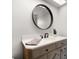 Stylish bathroom vanity with a round mirror and modern fixtures at 2567 Frisco Dr, Clearwater, FL 33761