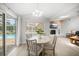 Cozy dining area adjacent to a fireplace, with a pool view through sliding glass doors at 2567 Frisco Dr, Clearwater, FL 33761