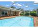 Relaxing screened-in pool with brick-paver surround and covered patio featuring seating area at 2567 Frisco Dr, Clearwater, FL 33761