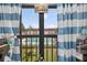 Balcony view overlooking the community pool and lush greenery, framed by blue and white striped curtains at 2591 Countryside Blvd # 5304, Clearwater, FL 33761