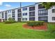 Well-maintained exterior of building with balconies, landscaping, and lush green lawn at 2591 Countryside Blvd # 5304, Clearwater, FL 33761