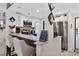 Updated kitchen with breakfast bar, granite countertops, stainless steel appliances, white cabinets, and open to living area at 2591 Countryside Blvd # 5304, Clearwater, FL 33761